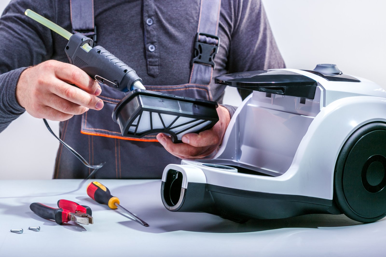 Vacuum specialist repairing vacuum cleaner for customer.